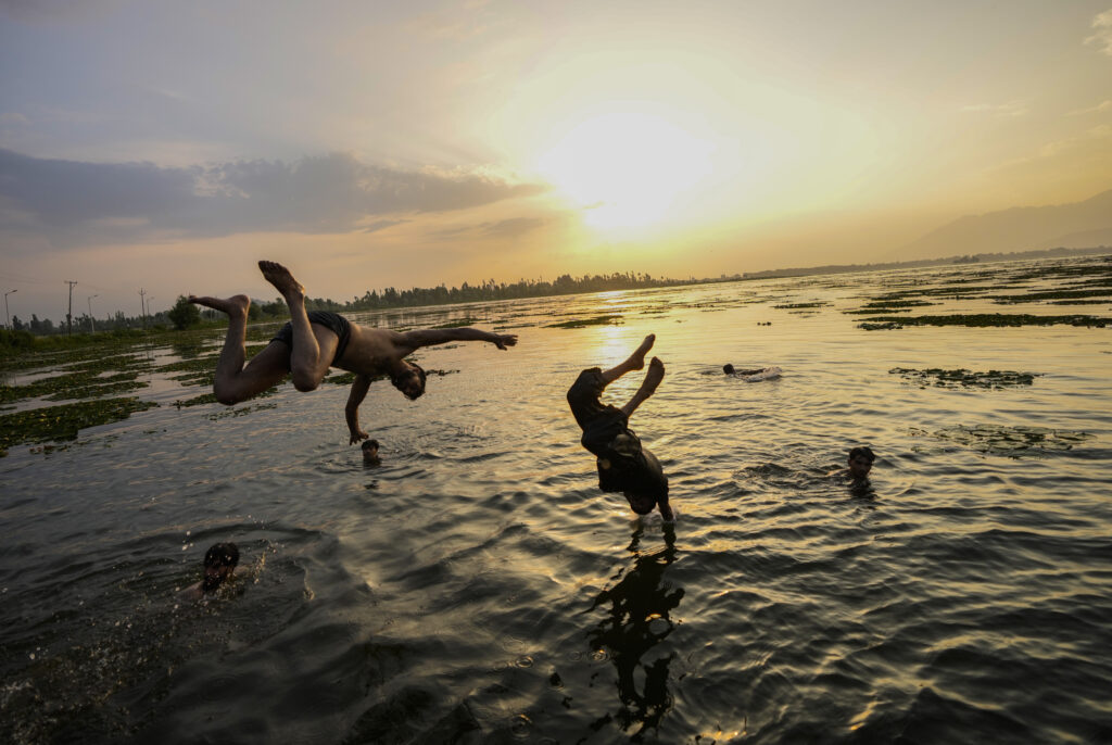 Kashmiri boys jump into the Dal Lake during a hot summer day in Srinagar, Indian controlled Kashmir, Tuesday, July 2, 2024. (AP Photo/Mukhtar Khan)