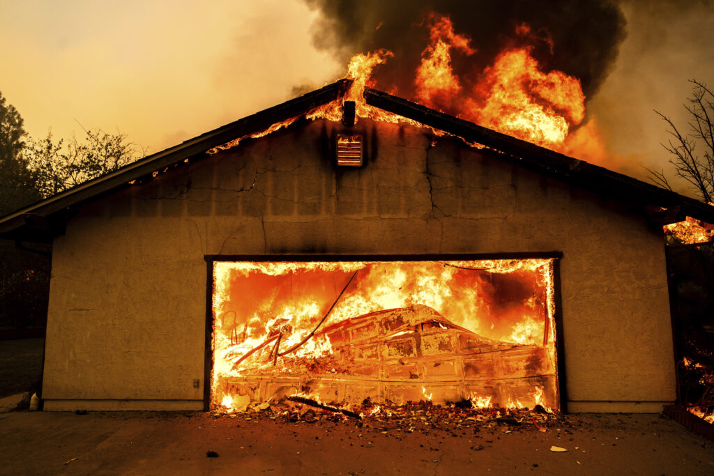 Flames consume a garage as the Thompson Fire burns in Oroville, Calif., Tuesday, July 2, 2024. An extended heat wave blanketing Northern California has resulted in red flag fire warnings and power shutoffs. (AP Photo/Noah Berger)