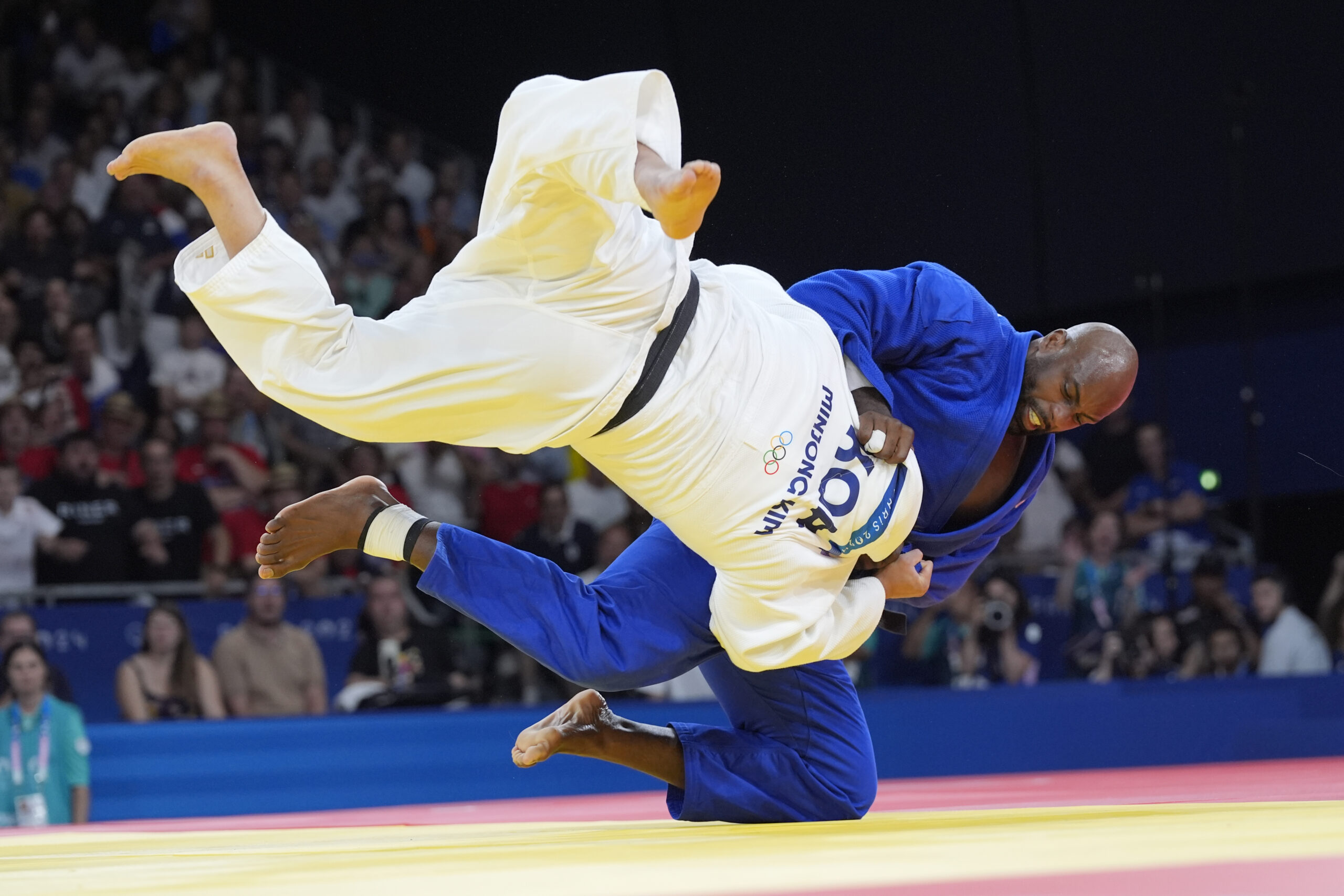 South Korea's Kim Min-jong and France's Teddy Riner compete during their men's +100 kg final match in the team judo competition, at Champ-de-Mars Arena, during the 2024 Summer Olympics, Friday, Aug. 2, 2024, in Paris, France. (AP Photo/Eugene Hoshiko)