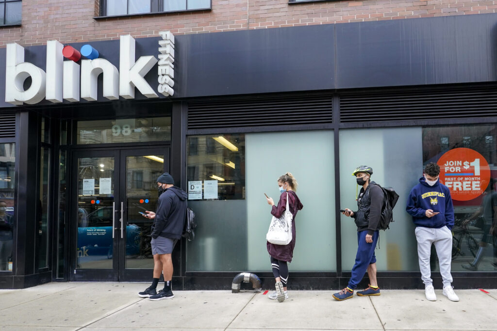 People line up outside the Blink Fitness gym, March 26, 2021, in the Lower East Side neighborhood of New York. AP Photo/Mary Altaffer, File