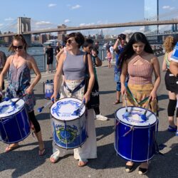 Visitors to Brooklyn Bridge Park recently joined a drum line with members of the group Fogo Azul. Photo: Mary Frost, Brooklyn Eagle