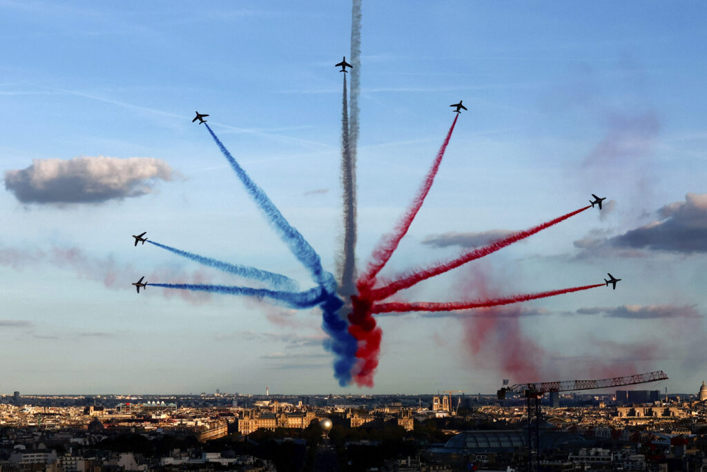 The Patrouille de France, an aerobatics demonstration unit of the French Air Force, trail smoke as they fly over Paris during a parade for French athletes who participated in the 2024 Olympics and Paralympics, Saturday, Sept. 14, 2024 in Paris.(Gonzalo Fuentes/Pool Photo via AP)