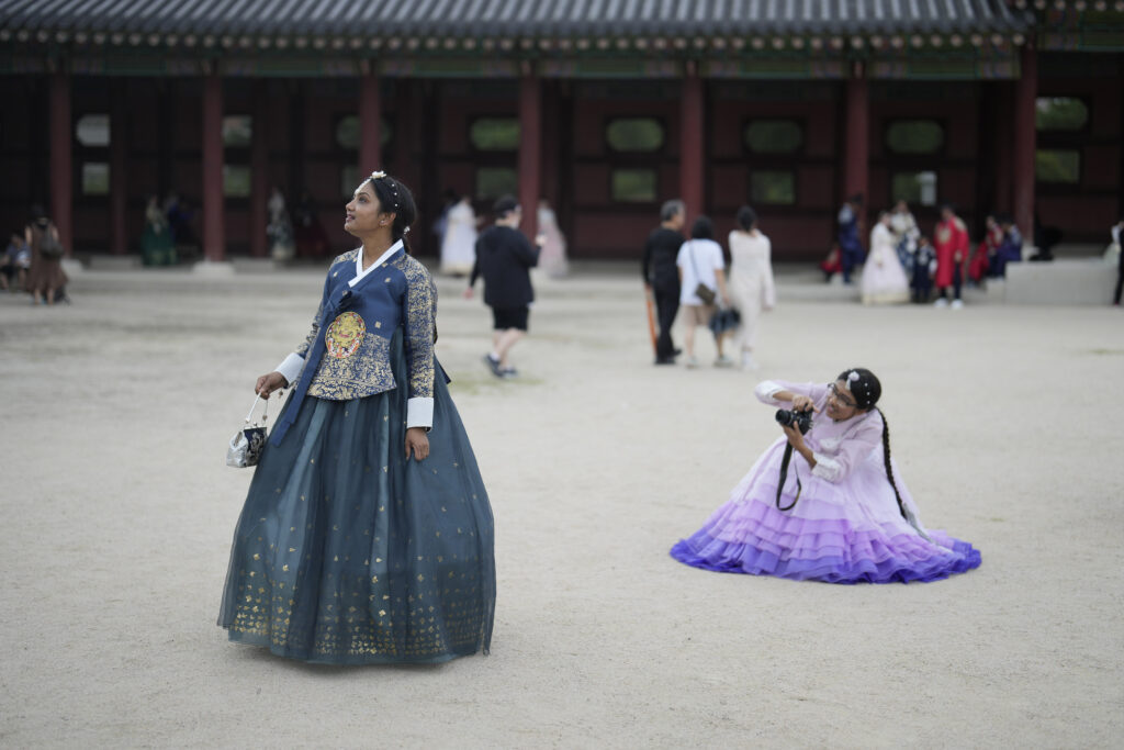 Shithi Tabassum, right, and Naher Tanzila, left, from Bangladesh, dressed in South Korean traditional "Hanbok" attire, pose for their souvenir photos at the Gyeongbok Palace, one of South Korea's well-known landmarks, during the Chuseok holidays, the Korean version of Thanksgiving Day, in Seoul, South Korea, Tuesday, Sept. 17, 2024. (AP Photo/Lee Jin-man)