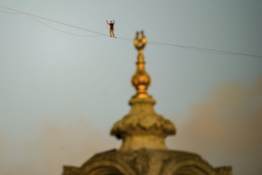 Estonian athlete Jaan Roose walks on slackline across the July 15 bridge crossing the Bosphorus from the Asian to the European side, in Istanbul, Turkey, Sunday, Sept. 15, 2024. (AP Photo/Emrah Gurel)