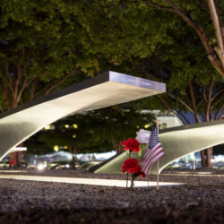 Flowers and a flag adorn one of the memorial benches outside the Pentagon before the start of a dawn 9/11 remembrance ceremony on Wednesday, Sept. 11, 2024 in Washington. (AP Photo/Kevin Wolf)