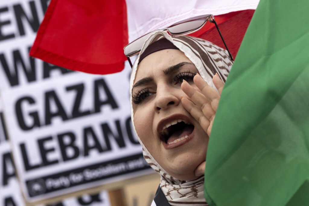 A protester waves a Lebanese flag as demonstrators gather to protest against the war on Gaza and Israeli military strikes on Lebanon in front of the Los Angeles Federal Building on Tuesday, Sept. 24, 2024, in Los Angeles. (AP Photo/Etienne Laurent)