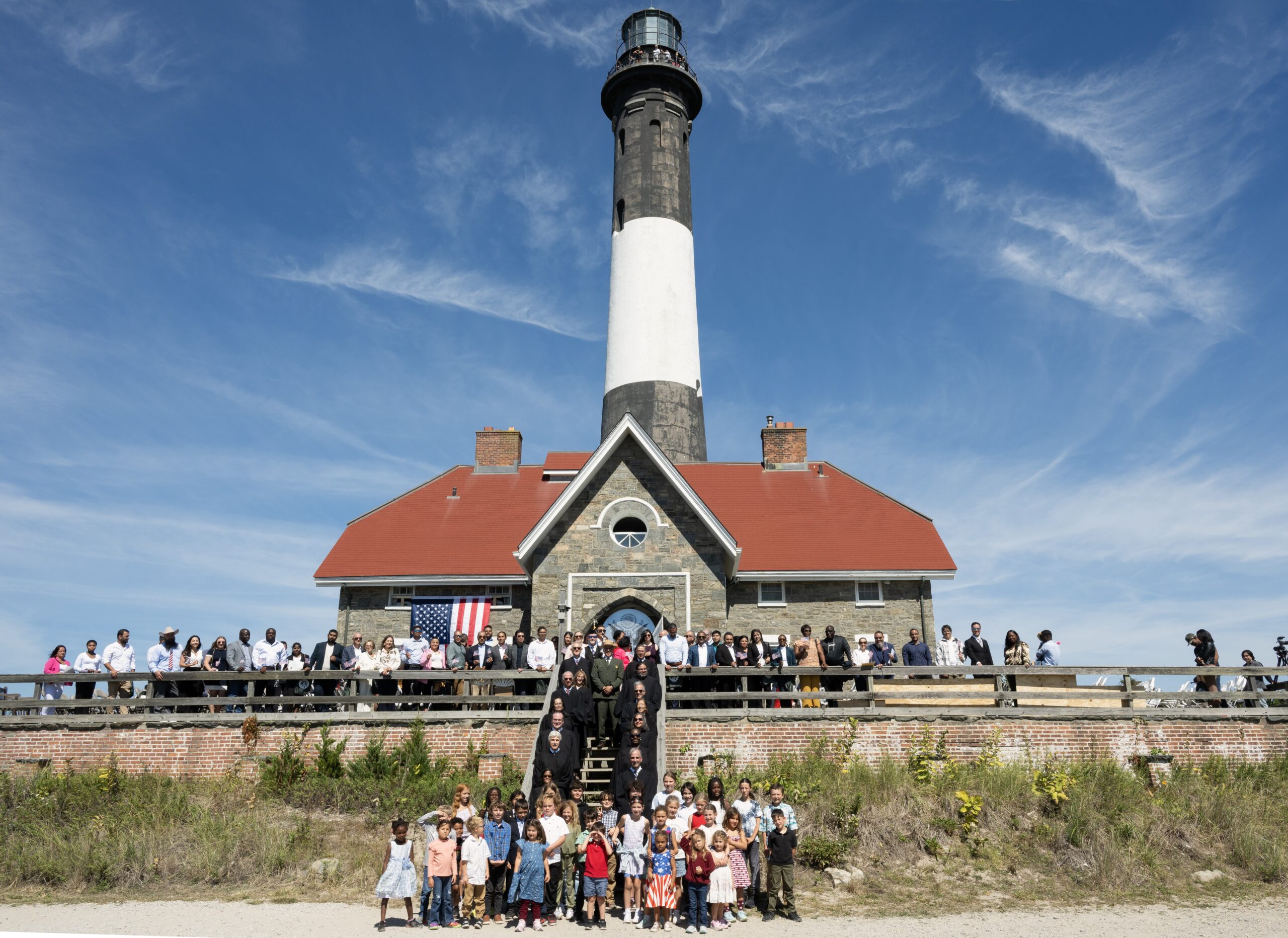 The first-ever naturalization ceremony at Fire Island National Seashore took place in front of the iconic lighthouse, where new citizens, judges, and local dignitaries gathered to mark the occasion. Photo by Allison Morrissey, courtesy of the Second Circuit Library