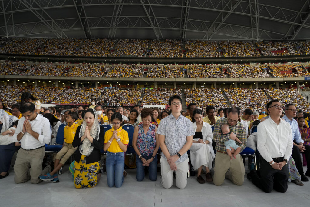 The faithful follow Pope Francis presiding over a mass 'In Memory of the Most Holy Name of Mary' celebrated by the Archbishop of Singapore, Cardinal William Goh Seng Chye at the Singapore SportsHub National Stadium, Thursday, Sept. 12, 2024. Pope Francis has praised Singapore's economic development as a testament to human ingenuity. But he's urging the city-state to look after the weakest too. Francis made the remarks Thursday on the final leg of the longest and farthest tour of his papacy. (AP Photo/Gregorio Borgia)