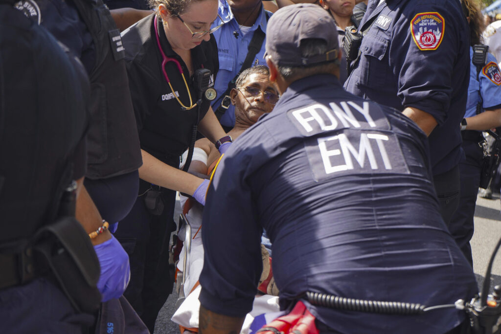 First responders tend to a man injured during a shooting at the West Indian Parade, Monday, Sept. 2, 2024, in the Brooklyn borough of New York.