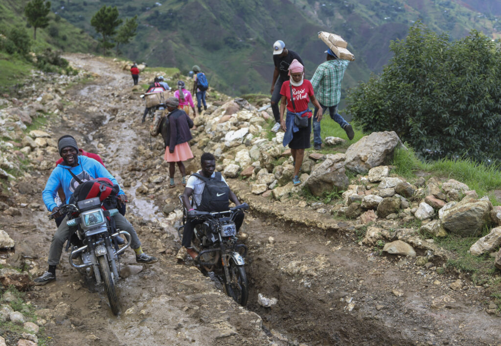 People traverse mountainous roads as they avoid gang violence in the Kenscoff neighborhood of Port-au-Prince, Haiti, Tuesday, Sept. 10, 2024. (AP Photo/Odelyn Joseph)