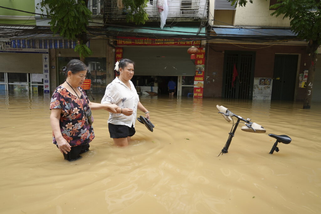 People wade in a flooded street in the aftermath of Typhoon Yagi, in Hanoi, Vietnam on Thursday, Sept. 12, 2024. (AP Photo/Hau Dinh)