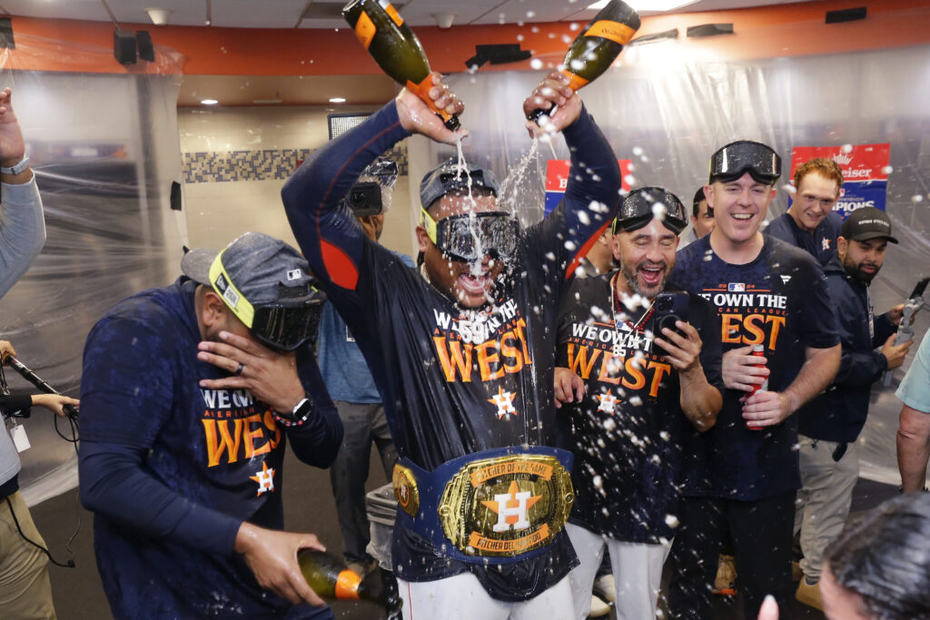 Houston Astros starting pitcher Framber Valdez, center, pours champagne on himself as the team celebrates in the clubhouse after defeating the Seattle Mariners 4-3 to clinch the AL West title after a baseball game Tuesday, Sept. 24, 2024, in Houston. (AP Photo/Michael Wyke)