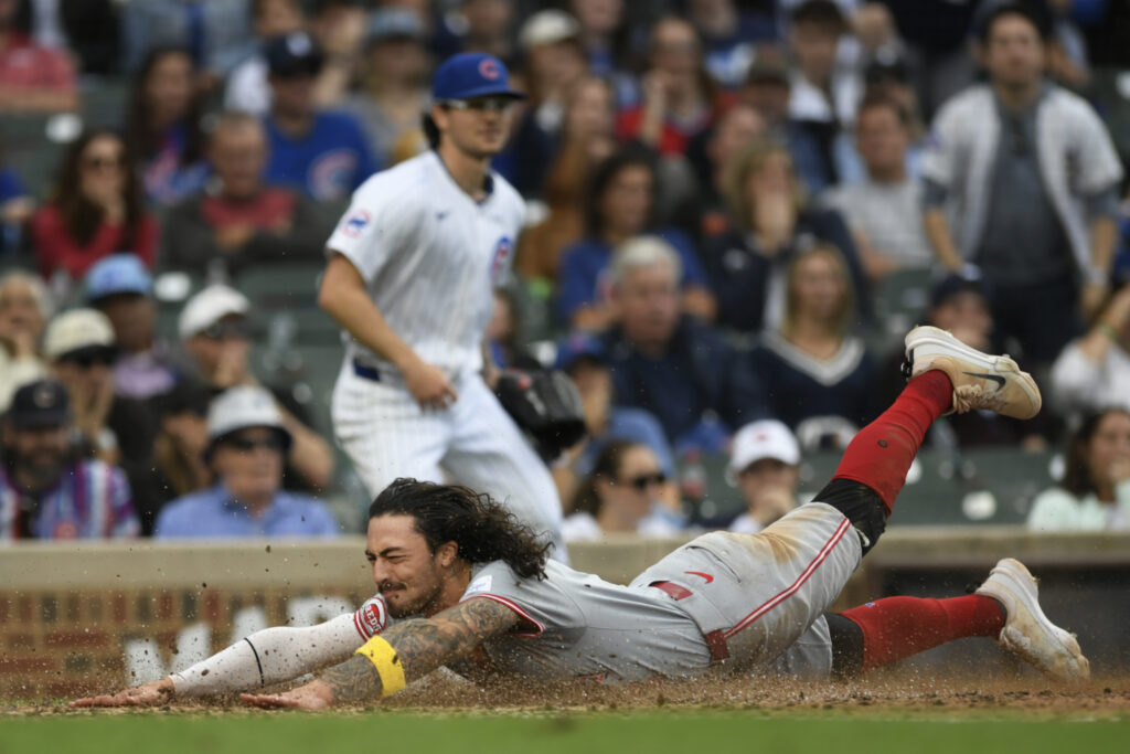 Cincinnati Reds' Jonathan India slides safely into home plate on a Elly De La Cruz 2 RBI double during the tenth inning of a baseball game against the Chicago Cubs in Chicago, Sunday, Sept. 29, 2024. (AP Photo/Paul Beaty)