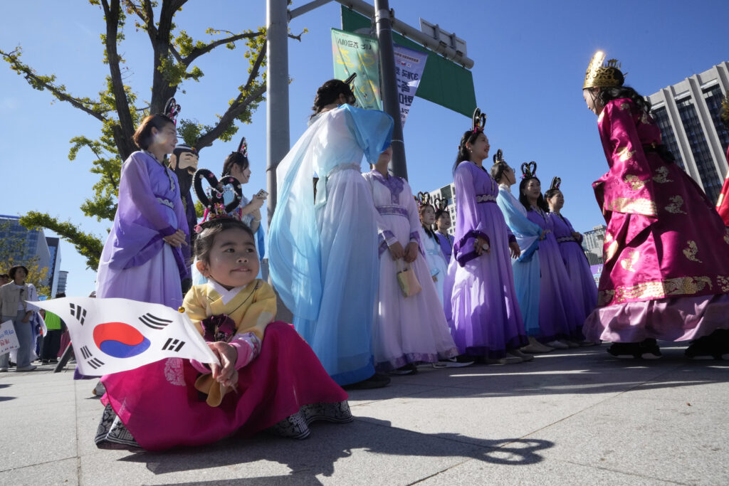 Kim Tae-yeon holds a national flag while waiting for a parade to celebrate the country's National Foundation Day in Seoul, South Korea, Thursday, Oct. 3, 2024. (AP Photo/Ahn Young-joon)