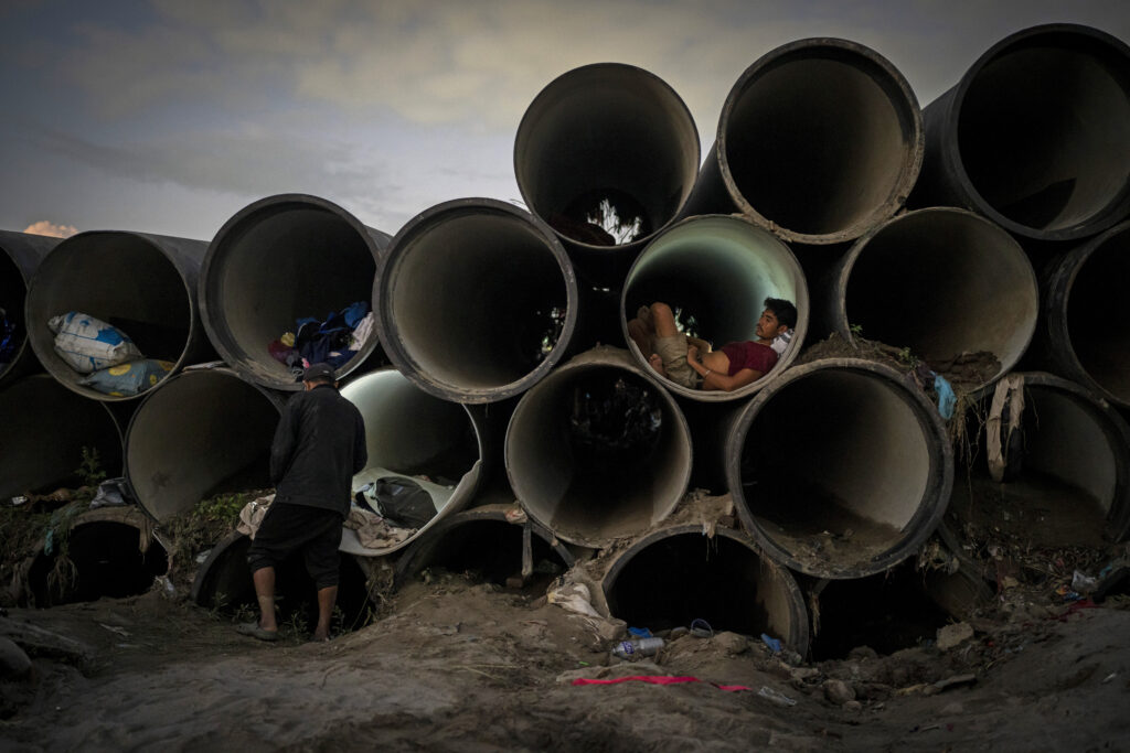 A man sits inside a concrete pipe meant for the municipal use after his shelter was swept away by the flooding Bagmati River in Kathmandu, Nepal, on Tuesday, Oct. 1, 2024. (AP Photo/Niranjan Shrestha)