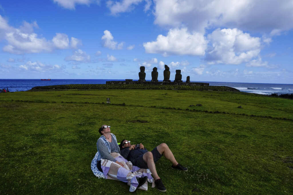 People watch the annular solar eclipse in Tahai, Rapa Nui, or Easter Island, Chile, Wednesday, Oct. 2, 2024. (AP Photo/Esteban Felix)