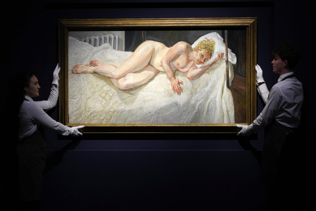 Art handlers arrange 'Ria, Naked Portrait' by Lucian Freud as it is displayed at Christie's auction rooms, the painting estimated at 10-15 million UK pounds will be for auction in the 20th/21st Century London Evening Sale at Christie's in London, Thursday, Oct. 3, 2024. (AP Photo/Kirsty Wigglesworth)