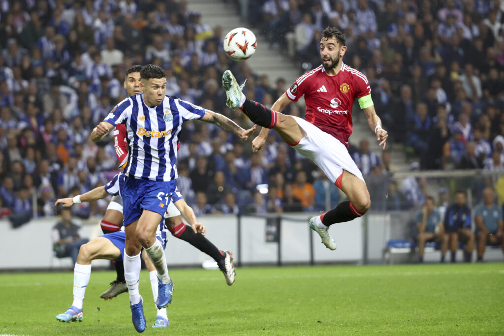 Manchester United's Bruno Fernandes, right, reaches for the ball too high and close to the head of Porto's Nehuen Perez to see a second yellow card and be sent off, during a Europa League opening phase soccer match between FC Porto and Manchester United at the Dragao stadium in Porto, Portugal, Thursday, Oct. 3, 2024. (AP Photo/Luis Vieira)