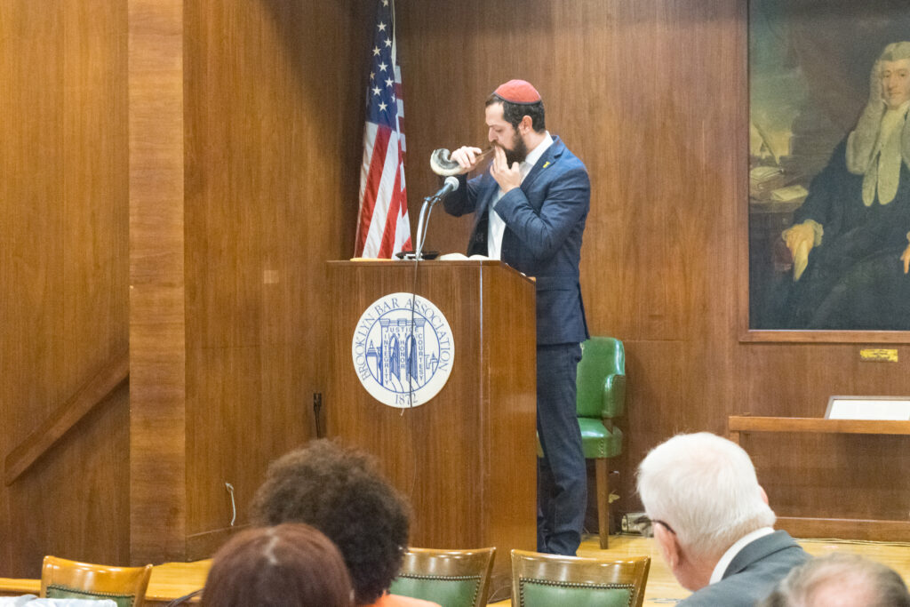 Rabbi Eliyahu Raskin blows the shofar during the Brooklyn Brandeis Society and Chabad Tzedek Society’s New Year event at the Brooklyn Bar Association. The ceremony, held on Oct. 8, honored the victims of the Oct. 7 tragedy and focused on hope and remembrance. Brooklyn Eagle photo by Robert Abruzzese