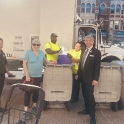 A community member handing her paper over to be shredded. Photo by Wayne Daren Schneiderman