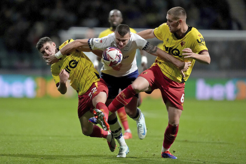 Preston North End's Milutin Osmajic, center, and Watford's Mattie Pollock, right, and James Morris battle for the ball during a Sky Bet Championship soccer match at Deepdale, Wednesday, Oct. 2, 2024, in Preston, England. (Martin Rickett/PA via AP)