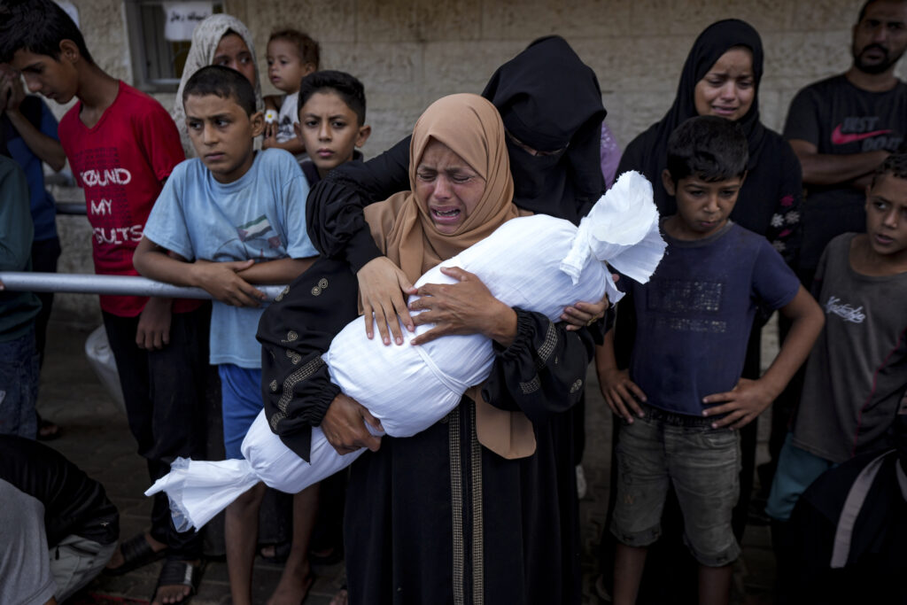 Palestinians mourn relatives killed in the Israeli bombardment of the Gaza Strip, at a hospital in Deir al-Balah, Tuesday, Oct. 1, 2024. (AP Photo/Abdel Kareem Hana)