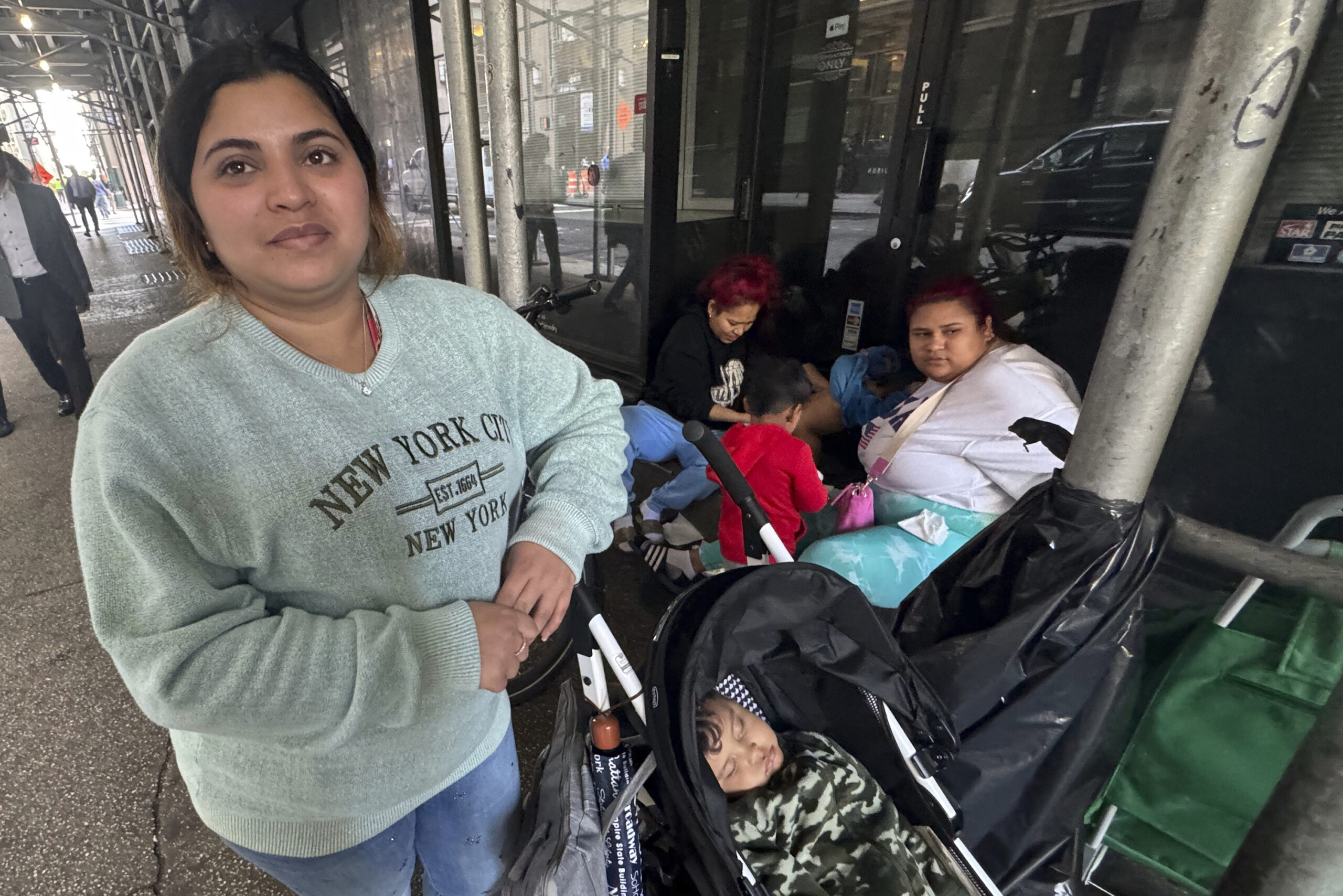 Maribel Hidalgo, 23, of Caracas, Venezuela, stands for a portrait with her son, Daniel, 2, outside a shelter for immigrants in New York, on Wednesday, Nov. 6, 2024. AP Photo/Cedar Attanasio