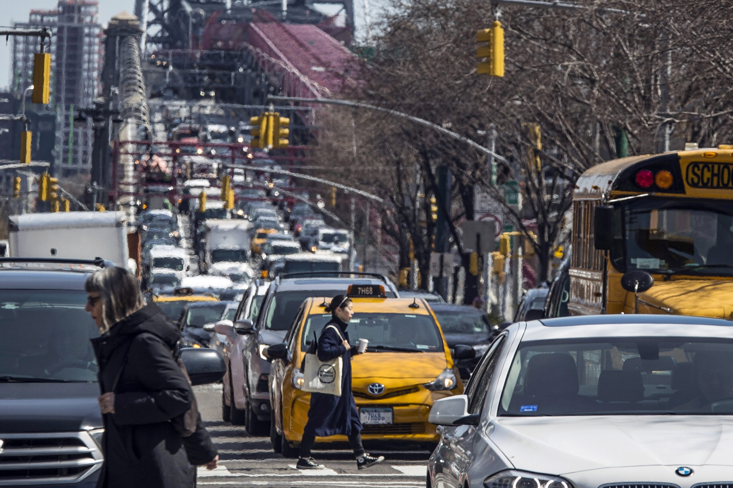 Pedestrians cross Delancey Street as congested traffic from Brooklyn enters Manhattan over the Williamsburg Bridge, March 28, 2019, in New York. AP Photo/Mary Altaffer, File