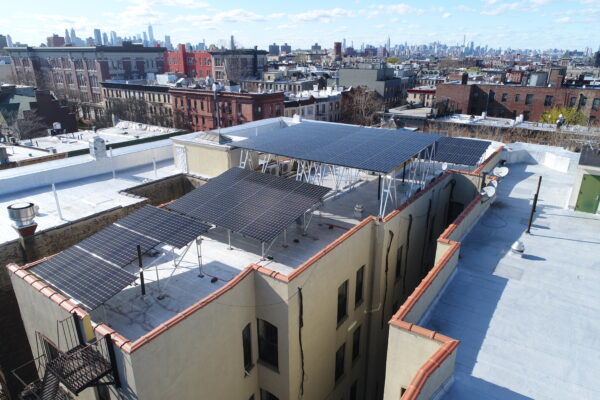 Installed in 2017, this 8-unit co-op in Crown Heights was the first affordable housing co-op in NYC to install an onsite community solar system. Using a hybrid design made up of 100 LG solar panels (33kW), this co-op was able to offset their common area electricity needs and provide energy savings to individual shareholders. Photo courtesy of Brooklyn SolarWorks