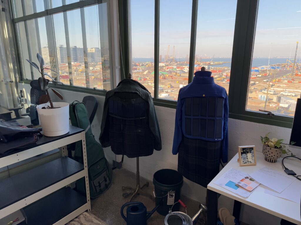 The two limited edition solar-powered jackets from Pvilion's collaboration with Tommy Hilfiger overlooking Gowanus Bay. Brooklyn Eagle photo by Andrew Scott
