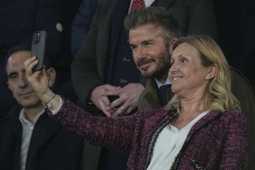 Former England soccer player David Beckham, center, poses for a photo with a spectator before the Champions League round of 16 first leg soccer match between Paris Saint-Germain and Liverpool at the Parc des Princes in Paris, Wednesday, March 5, 2025.