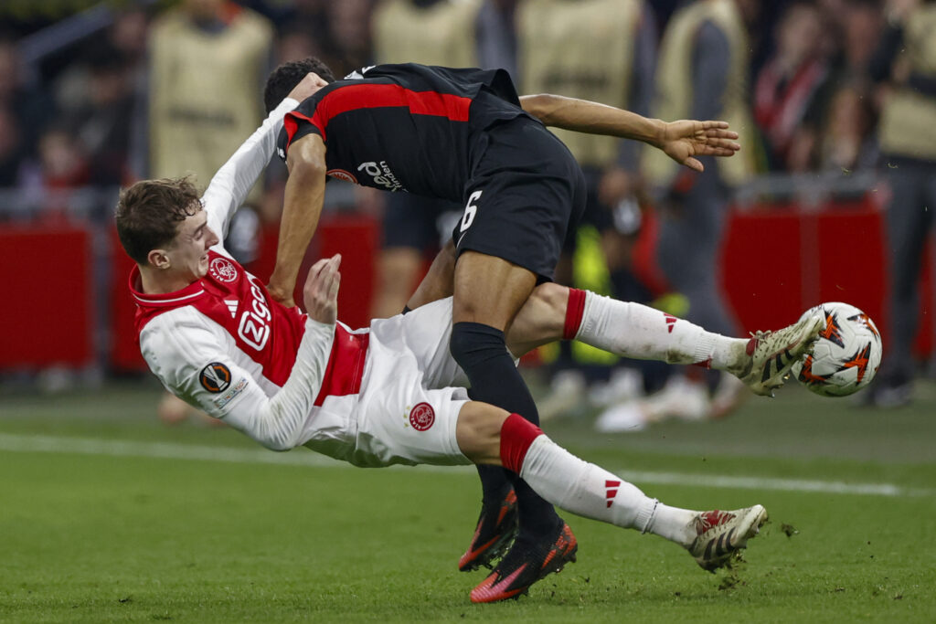 Eintracht Frankfurt's Ansgar Knauff, top, duels for the ball with Ajax's Youri Baas during the Europa League round of 16 first leg soccer match between Ajax and Eintracht Frankfurt at the Johan Cruyff ArenA in Amsterdam, Netherlands, Thursday, March 6, 2025.