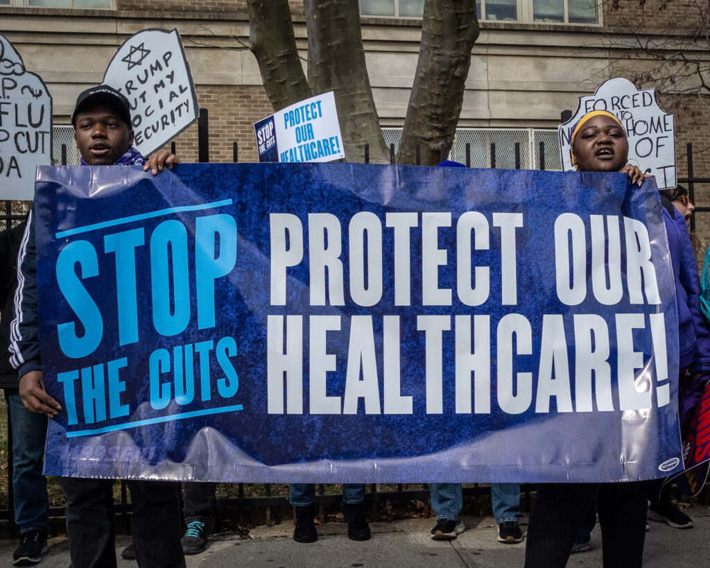 A coalition of progressive organizations and unions, including Indivisible Brooklyn and 1199 SEIU United Healthcare Workers East, rally in the Bay Ridge neighborhood of Brooklyn, New York, on March 22, 2025, against the funding cuts to federal health care programs and tax breaks for billionaires. Brooklyn Eagle photo by Gabriele Holtermann