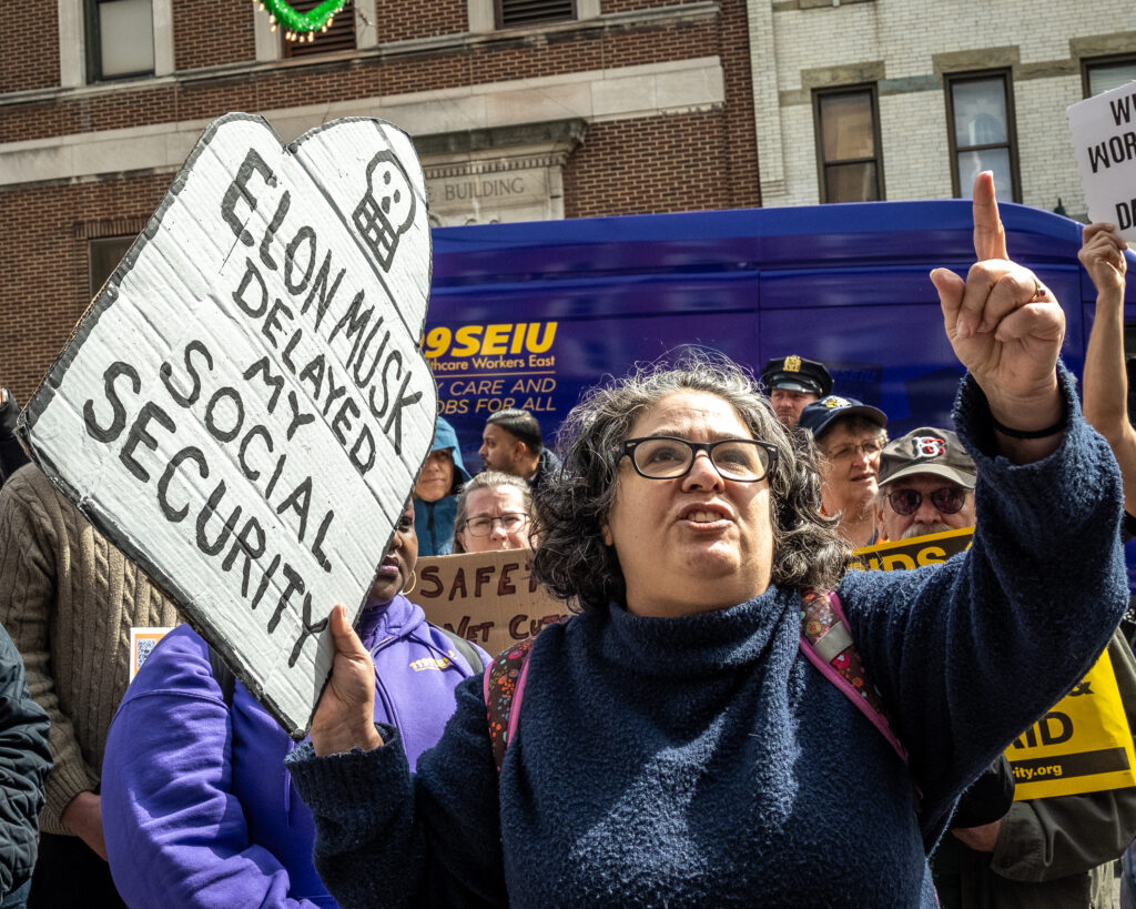 Irene (last name withheld) speaks at a rally outside the Bay Ridge office of Congresswoman Nicole Malliotakis (R-Brooklyn), in Brooklyn, New York, March 22, 2025, protesting Malliotakis’ vote to cut funding for federal health care programs while handing tax breaks to billionaires. Brooklyn Eagle photo by Gabriele Holtermann