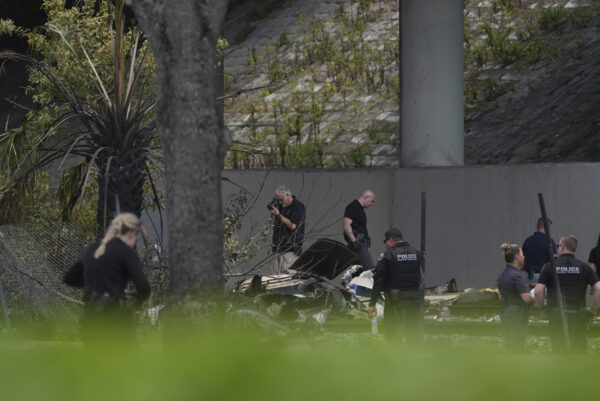 Emergency personnel respond to the area where a small plane crashed on the railroad tracks beneath the overpass near Interstate 95 in Boca Raton, Fla., on Friday, April 11, 2025. AP Photo/Marta Lavandier