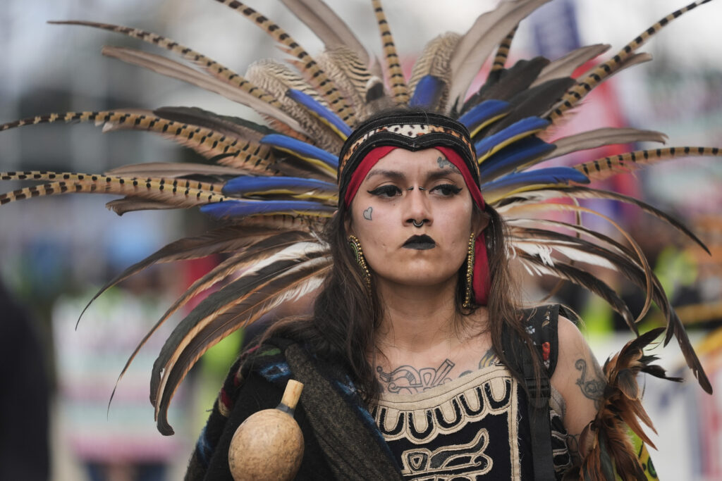 Jasmine Flores wears indigenous Mexican clothing as she and thousands of people march in a May Day rally and protest Thursday, May 1, 2025, in Chicago.