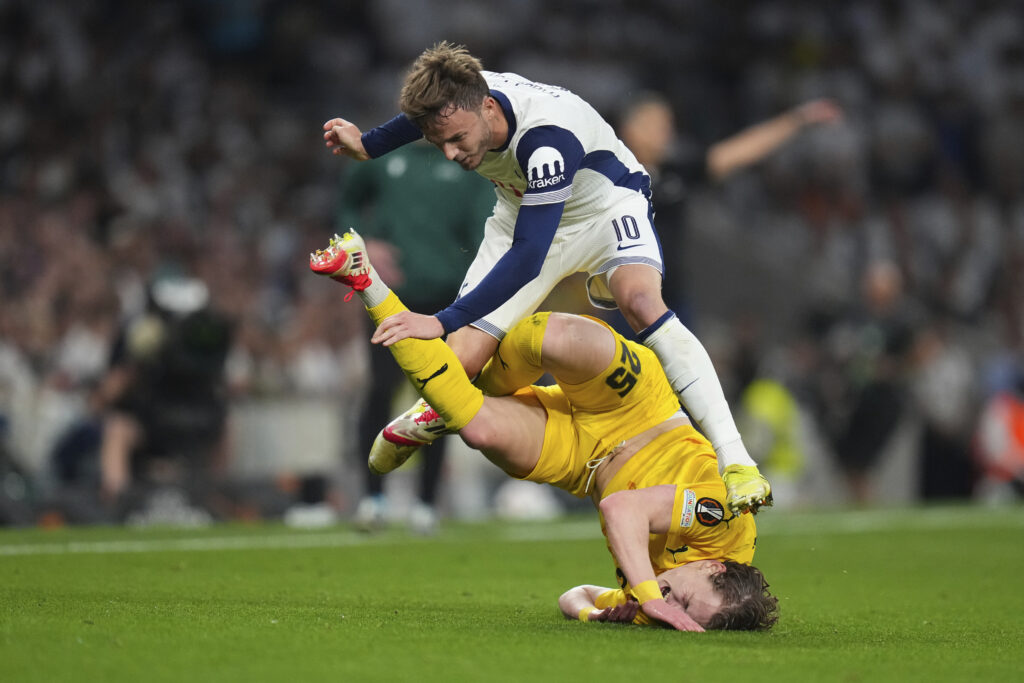 Tottenham's James Maddison jumps over Glimt's Isak Dybvik Maatta during the Europa League semifinal first leg soccer match between Tottenham Hotspur and Bodo/Glimt at the White Hart Lane stadium in London, Thursday, May 1, 2025.
