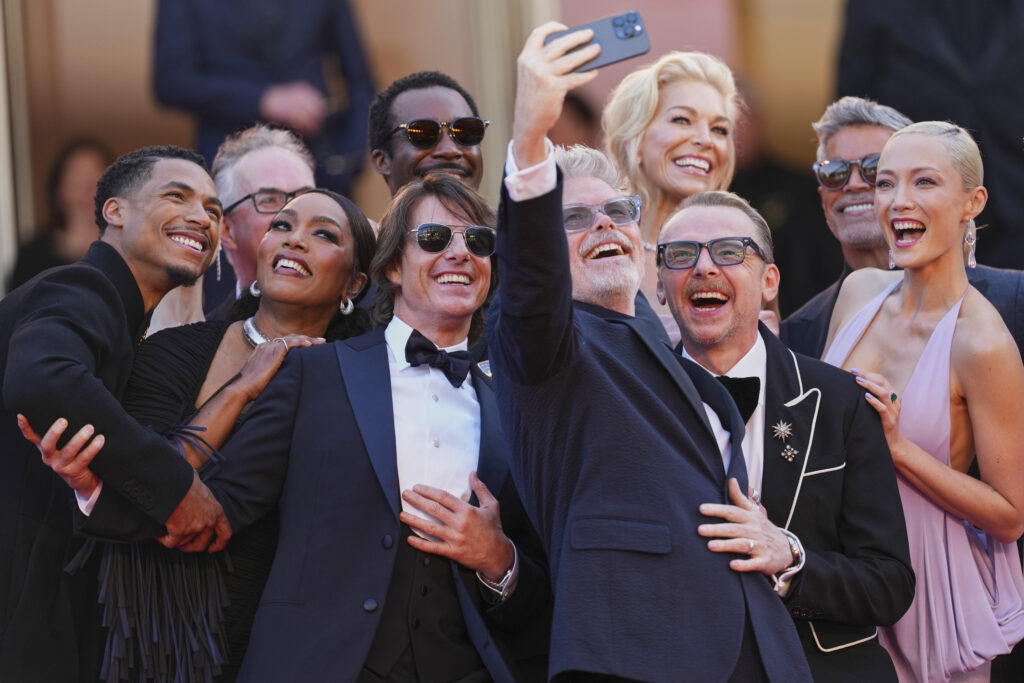 Greg Tarzan Davis, from left, editor Eddie Hamilton, Angela Bassett, Tramell Tillman, Tom Cruise, director Christopher McQuarrie, Hannah Waddingham, Simon Pegg, Esai Morales, and Pom Klementieff take a selfie upon arrival at the premiere of the film 'Mission: Impossible - The Final Reckoning' at the 78th international film festival, Cannes, southern France, Wednesday, May 14, 2025.