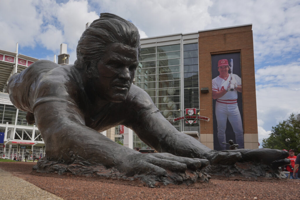 A bronze statue and a banner of former Cincinnati Reds player Pete Rose are seen outside the Great American Ball Park, Tuesday, May 13, 2025, in Cincinnati.