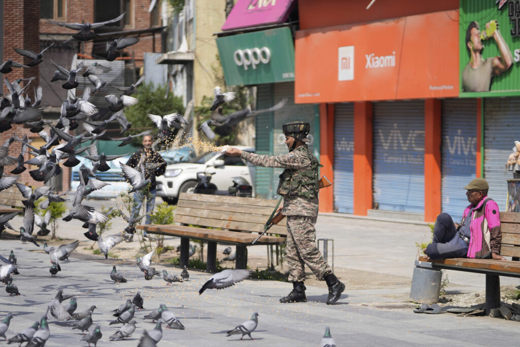 An Indian soldier feeds pigeons at a market, day after India and Pakistan agreed to a ceasefire Saturday following U.S.-led talks to end the most serious military confrontation between the nuclear-armed rivals in decades, in Srinagar, in Indian controlled Kashmir, Sunday, May 11, 2025.