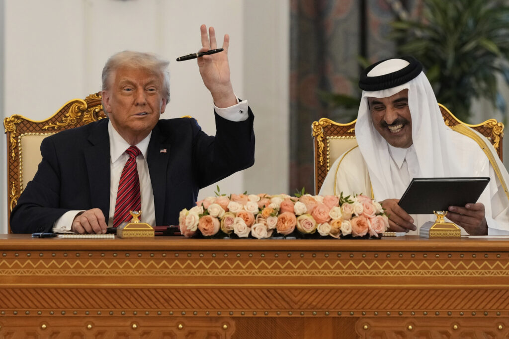 President Donald Trump holds up a pen given by Qatar's Emir Sheikh Tamim bin Hamad Al Thani as they exchange documents during a signing ceremony at the Amiri Diwan in Doha, Qatar, Wednesday, May 14, 2025.