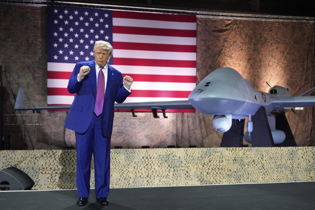 President Donald Trump gestures backdropped by an MQ-9 Reaper drone at the Al Udeid Air Base, Thursday, May 15, 2025, in Doha, Qatar.