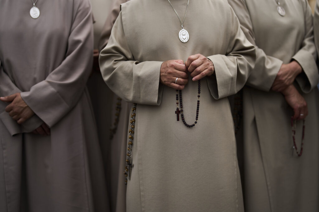 Nuns hold rosaries as Pope Leo XIV appears at the central balcony of St. Peter's Basilica for his first Sunday blessing after his election, in St. Peter's Square at the Vatican, Sunday, May 11, 2025.