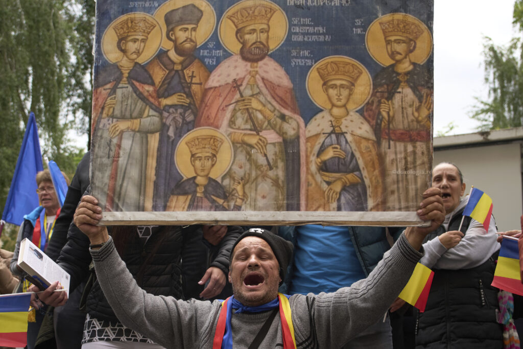 Supporters of Calin Georgescu, the winner of the first round of last year's annulled election, chant slogans during his appearance at a prosecutor's office in Bucharest, Romania, Tuesday, May 27, 2025.