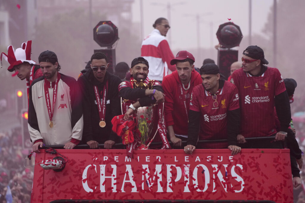 Liverpool's Mohamed Salah, center, celebrates with teammates and the trophy on an open-top bus during the Liverpool FC Premier League victory parade in Liverpool, England, Monday, May 26, 2025.