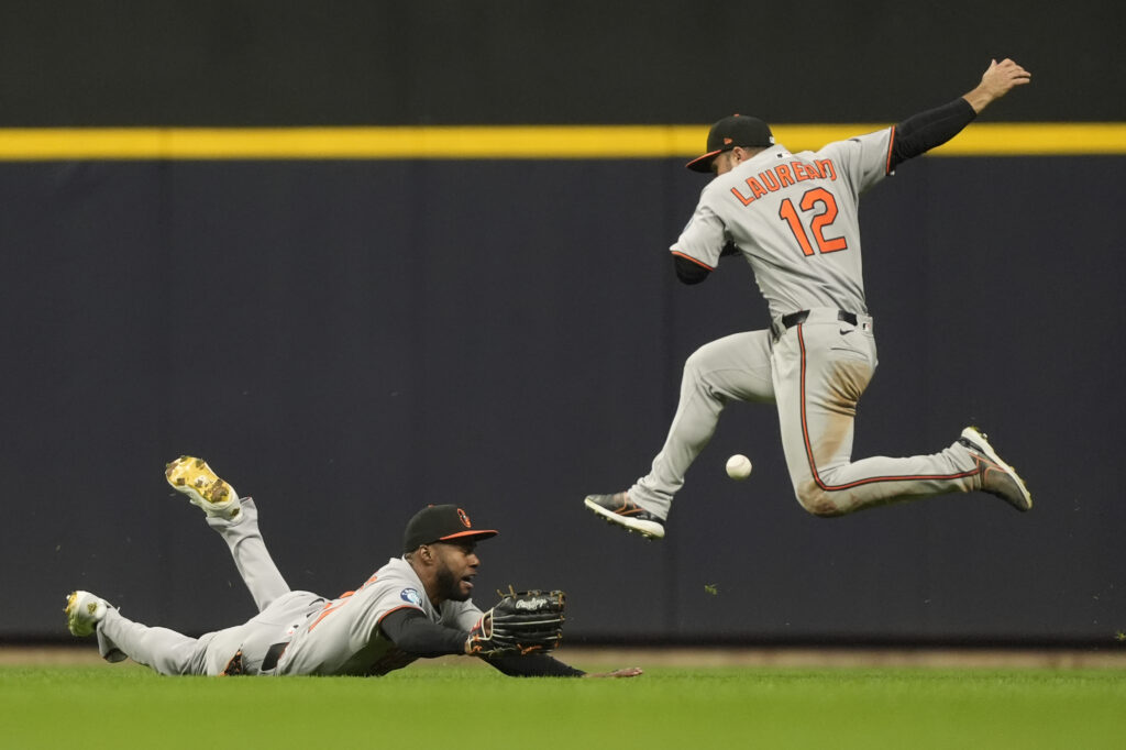 Baltimore Orioles' Cedric Mullins, left, and Ramón Laureano (12) are unable to catch a fly ball during the fifth inning of a baseball game against the Milwaukee Brewers, Monday, May 19, 2025, in Milwaukee.