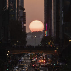 The sun sets as seen between buildings along 42nd Street in New York, May 30, 2023. AP Photo/Yuki Iwamura, file
