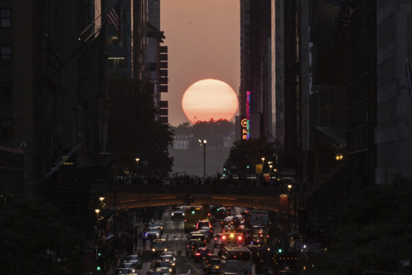 The sun sets as seen between buildings along 42nd Street in New York, May 30, 2023. AP Photo/Yuki Iwamura, file