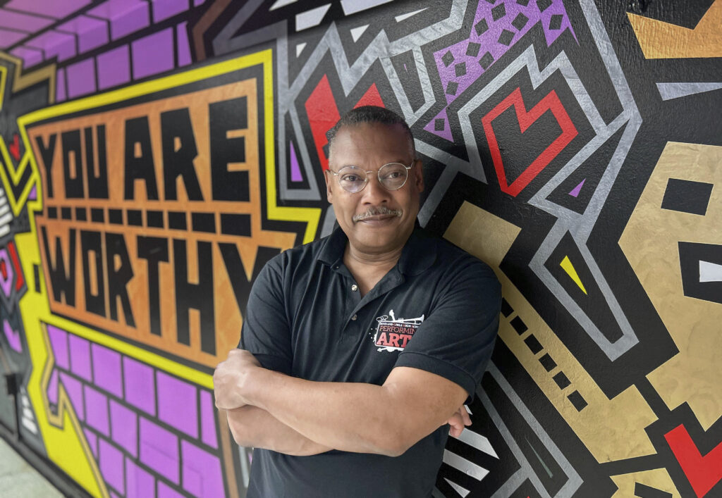This image released by Carnegie Mellon University shows Gary Edwin Robinson, recipient of the 2025 Excellence in Theatre Education Award, posing in front of a mural at the Boys and Girls High School in the Brooklyn borough of New York on May 7, 2025. Pam Wigley/Carnegie Mellon University via AP