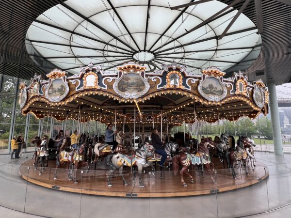 A select few taking a ride on Jane’s Carousel after the street renaming. Photo by Wayne Daren Schneiderman